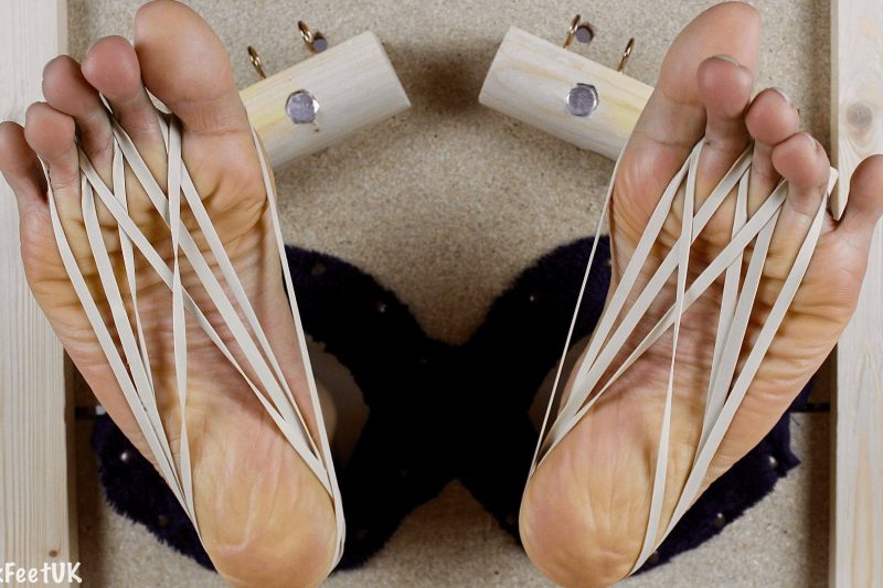 Toe clamps and elastic bands on #subtwink’s feet