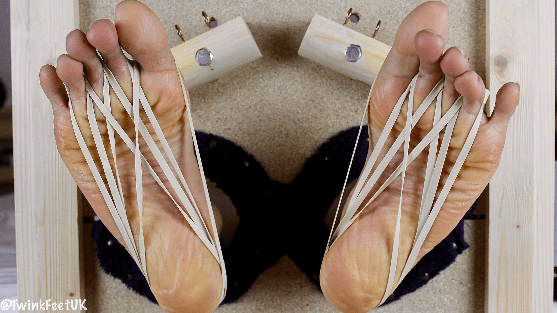 Toe clamps and elastic bands on #subtwink’s feet